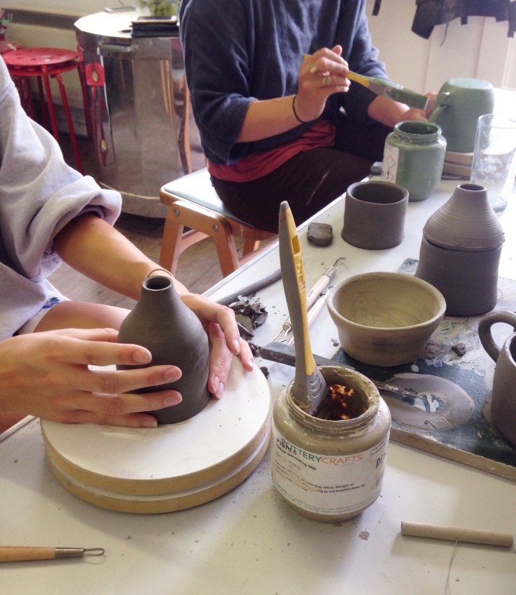 Two people making ceramic work in the workshop